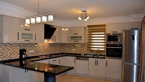 Una cocina moderna con una isla central, electrodomésticos integrados y un salpicadero decorativo.