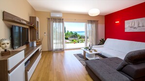 A living room with a sofa, a TV, and a dining table with food. -  Luxury villa with private heated pool, hot tub,  mini golf,  spacious inter... (Kaštel Kambelovac)