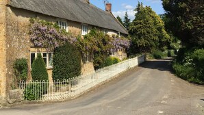A traditional stone building with a thatched roof, ivy-covered walls, and a white fence. - Atherstone Farm Cottage - charming thatched cottage, sleeps 4 guests in 2 rooms (Ilminster)