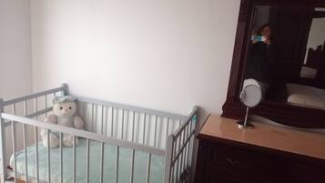 Cozy space with a crib and dresser, perfect for families.