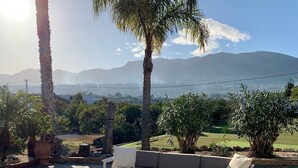 An outdoor seating area with a sofa and chairs, surrounded by palm trees and a view of distant mountains. - Luxury villa w/ stunning views in 2 acres of rural countryside - 30m from coast (Alhaurin el Grande, Málaga)