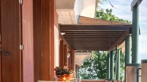 An outdoor patio with a table and chairs, a pergola, and a view of trees. - Delightful apartment with beautiful lake view (Desenzano del Garda)