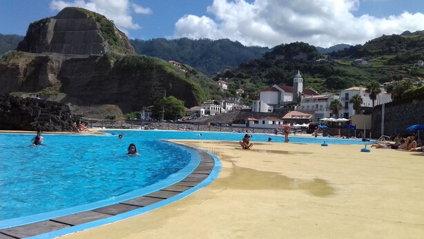A swimming pool with a sandy beach and a mountainous backdrop. - Vivenda Linda Vista 2  Spectacular sea and mountain views in Porto da Cruz (Porto Da Cruz)