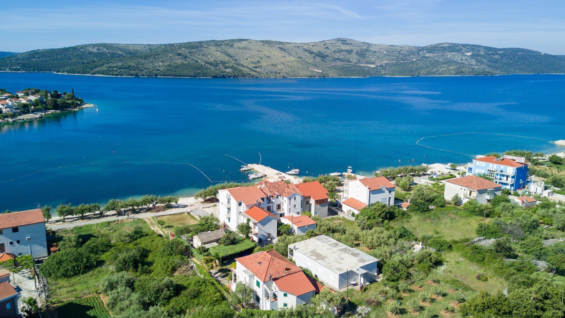 A coastal village with buildings and a clear view of the sea.