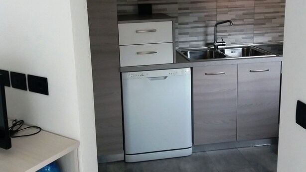 A modern kitchen with white cabinets, a built-in dishwasher, and a tiled backsplash. - Vacation Dimaro-Val di Sole CIN: IT022233C2QJN7YDD9 Apartment A (Dimaro)