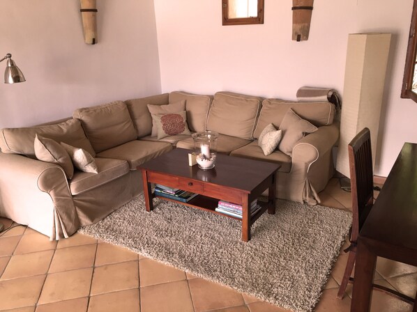 A living room with a beige sectional sofa, a wooden coffee table, and a tiled floor. - Holiday home in Soller with pool and amazing views. (Soller)