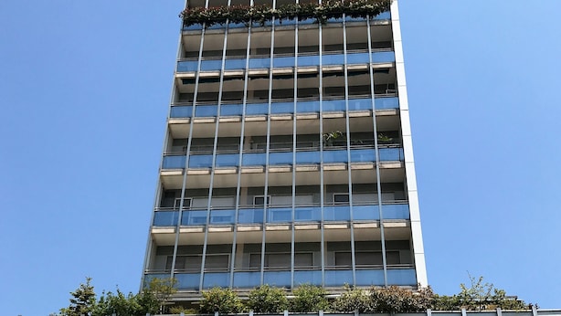 A modern high-rise building with a grid of windows and balconies. - Modern and cozy Italian experience (Mestre)