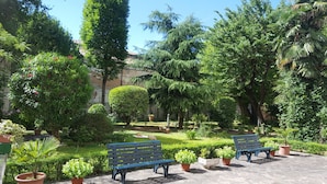 A garden with benches and potted plants. - Modern and cozy Italian experience (Mestre)