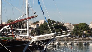 A large sailing ship docked at a marina with a cityscape in the background. - Family apartment in Stobrec (Stobrec)