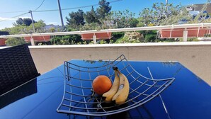 A blue car with a metal basket containing an orange and bananas on the hood. - Family apartment in Stobrec (Stobrec)