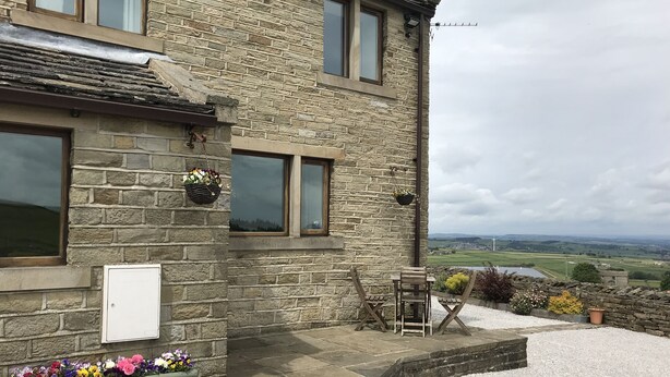 A stone building with a view of the countryside. - Law Brook Farm cottage with stunning views . (Hudderfield)