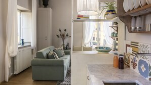 Een moderne woonkamer met een bank, een eethoek met een tafel, en een keuken met een spoelbak en kasten.