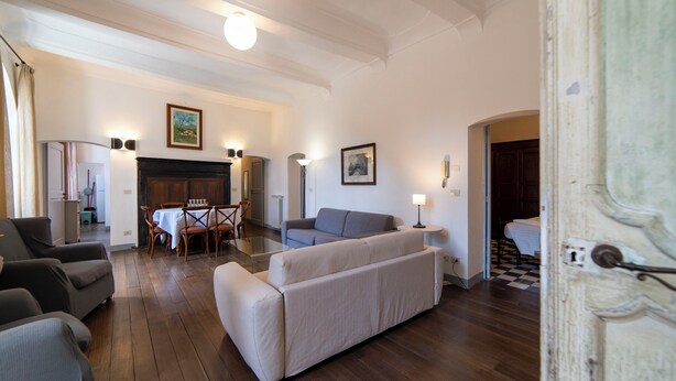 A living room with a sofa, chairs, a dining table, and a fireplace. - Large apartment at Residece Ca of NI - Finalborgo (Finale Ligure)