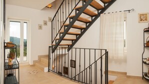 A staircase with wooden steps and black railings, leading to an upper floor.