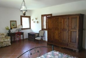 Relax in this cozy space with a large wardrobe, patterned sofa, and comfortable chair.
