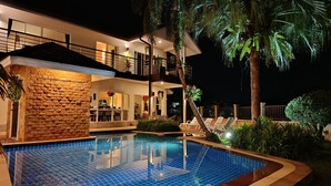 A modern house with a swimming pool, a balcony, and a well-lit outdoor area. - Wonderful Villa with Private Pool, Best Location! Walk to beach, restaurants etc (Khao Lak)