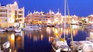 A marina with multiple boats docked, surrounded by multi-story buildings with balconies. - Sun-Drenched, Sea-View Apartment with Giant Patio, Private Garden and Garage (Fuengirola)