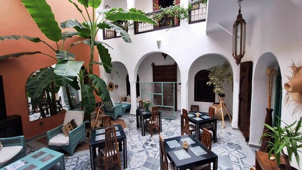 An indoor courtyard with multiple seating areas, tables, and potted plants. - RIAD 16 PEOPLE - HEART OF MEDINA, HOTEL SERVICE, HEATED POOL, JACUZZI SPA (Marrakesh)