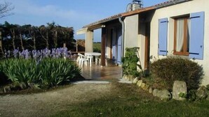 A house with a patio, a table, and chairs. - House bungalow with garden and terrace, 1100m2 property, 8 person,  (Saint-Denis-D'oléron)
