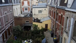 A narrow urban alley with buildings on either side, featuring a mix of residential and commercial properties. - Furnished apartment.  Close to the beach and shops.  (Berck)