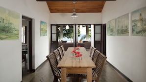 Un comedor con una mesa de madera, sillas y obras de arte en las paredes.