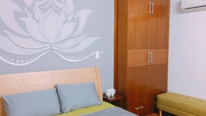 Une chambre à coucher comprenant un lit, une armoire, une table de chevet avec des tasses et un appareil de climatisation.