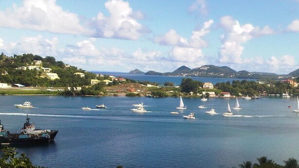 A coastal view with multiple sailboats and a cruise ship, surrounded by hills and buildings. - Affordable, Tranquil, St. Lucia Carnival, Bay View Apartment (Castries)