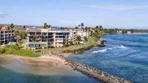 Un hotel frente al mar con varias edificaciones, una playa y un litoral rocoso.