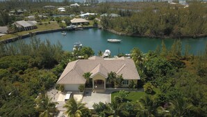 A large house with a spacious front yard, a swimming pool, and a view of the ocean. - 14ft Centre consul boat and car included Waterfront property with pool. (Freeport)