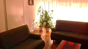 A living room with two sofas, a chandelier, a potted plant, and a window with sheer curtains. - Sea house Casa Passiflora, 10 min. beach, BBQ garden  (Pula)