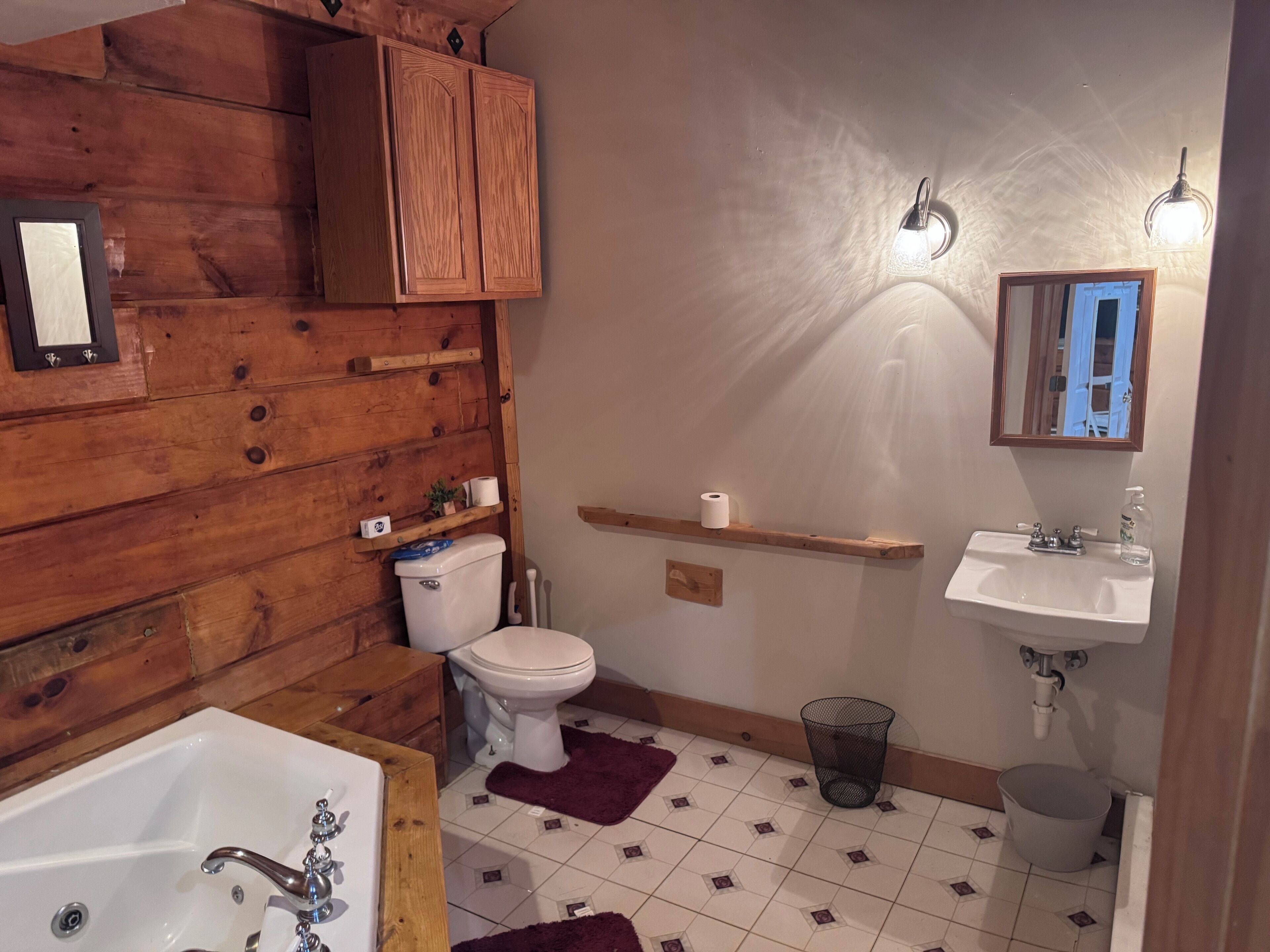 A bathroom with wooden walls, a white toilet, a white sink, and a bathtub.