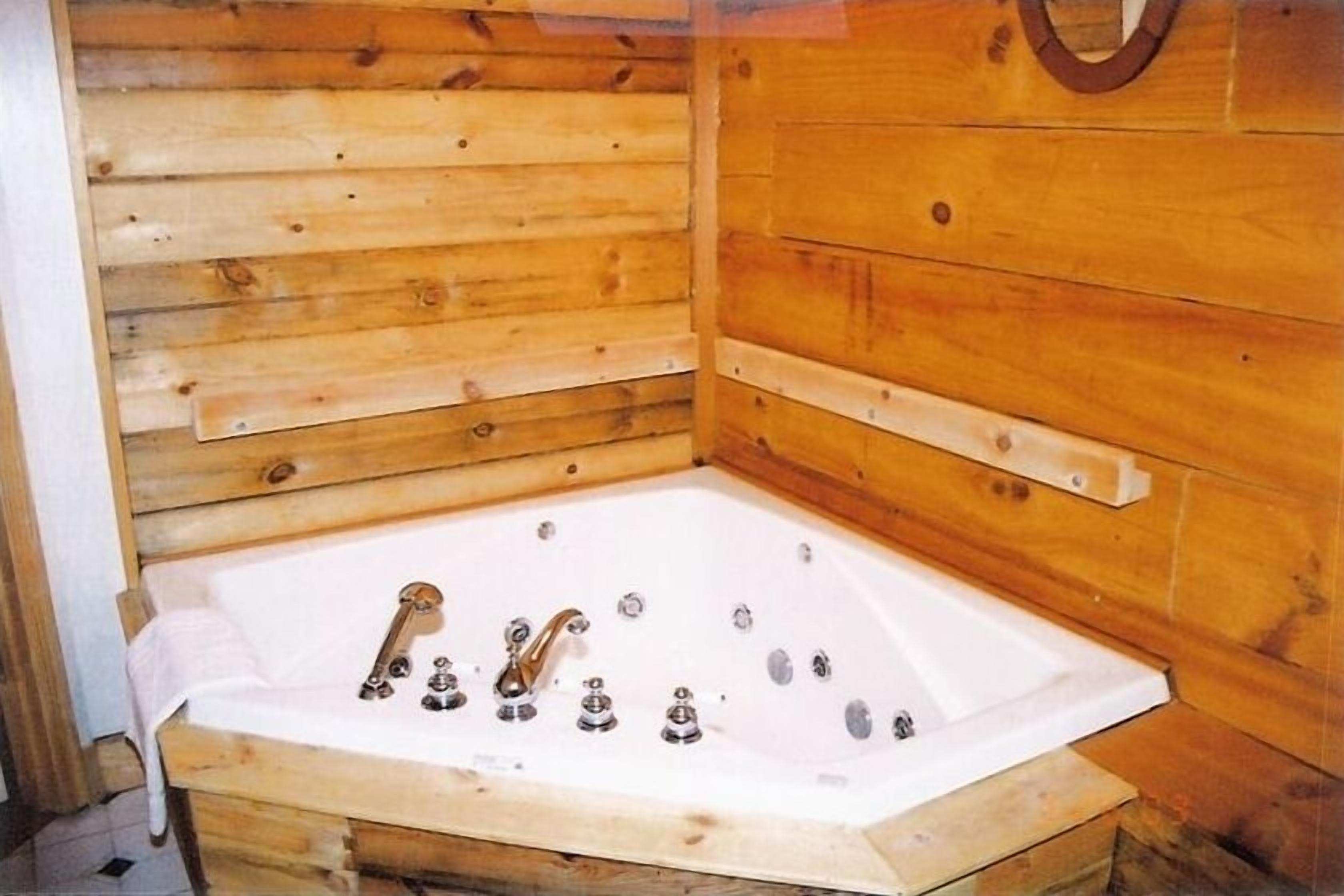 A wooden cabin with a corner bathtub.