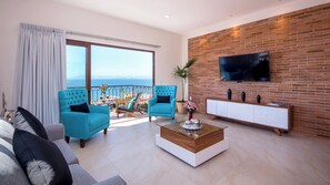 Un salon avec balcon, un téléviseur fixé au mur en briques et un canapé moderne.