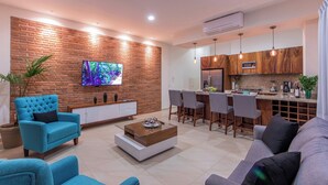A modern living room with a TV, sofa, and coffee table. - Penthouse in the heart of Gringo Gulch (Puerto Vallarta)
