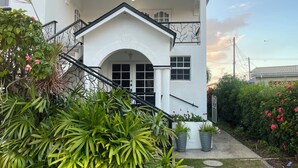 A white building with a black staircase leading to an arched entrance. - The Palms Areca-Attractive, Alluring and Aesthetically artistic (Bridgetown)
