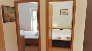 Een hotelkamer met een bed, een klein tafeltje met een lamp en een schilderij aan de muur.