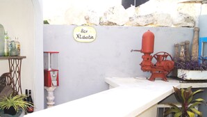 A bar area with a sign reading "Bar Xtabentun," a red fire extinguisher, and a vintage machine.