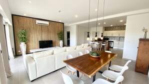 En moderne stue med en stor sofa, et træspisebord og et fjernsyn.