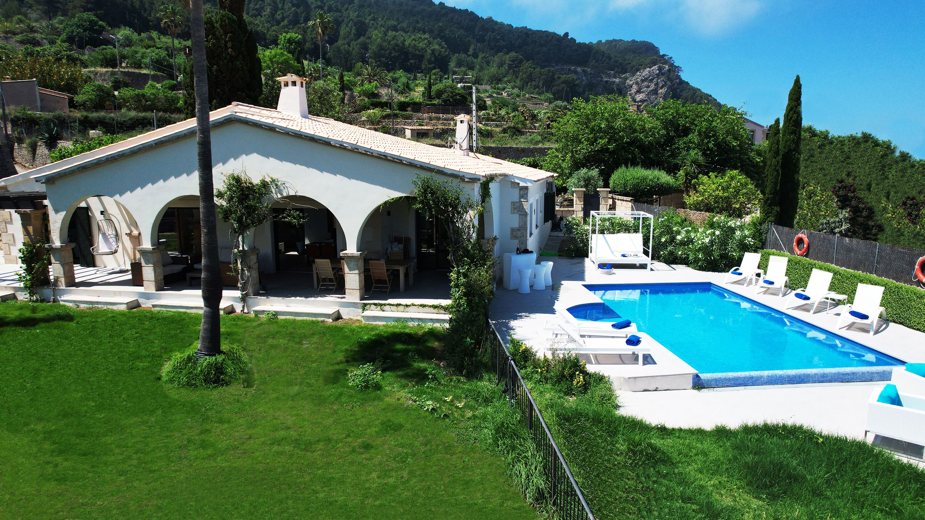 Una villa con piscina, area relax esterna e vista sul paesaggio circostante.