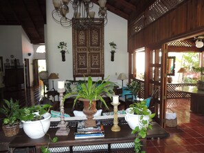 Cozy living area with a traditional ceiling, ornate door, and comfortable sofa.