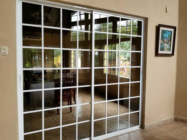 Una habitación con puerta corrediza de vidrio que da a un patio.