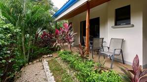 A covered outdoor area with a patio, chairs, and a variety of plants. - Only 350 meters from Tamarindo beach and downtown. In quiet and safe area. 
 (Tamarindo)