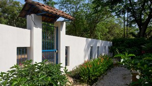 A modern house with a white exterior, blue window frames, and a tiled roof. - Only 350 meters from Tamarindo beach and downtown. In quiet and safe area. 
 (Tamarindo)