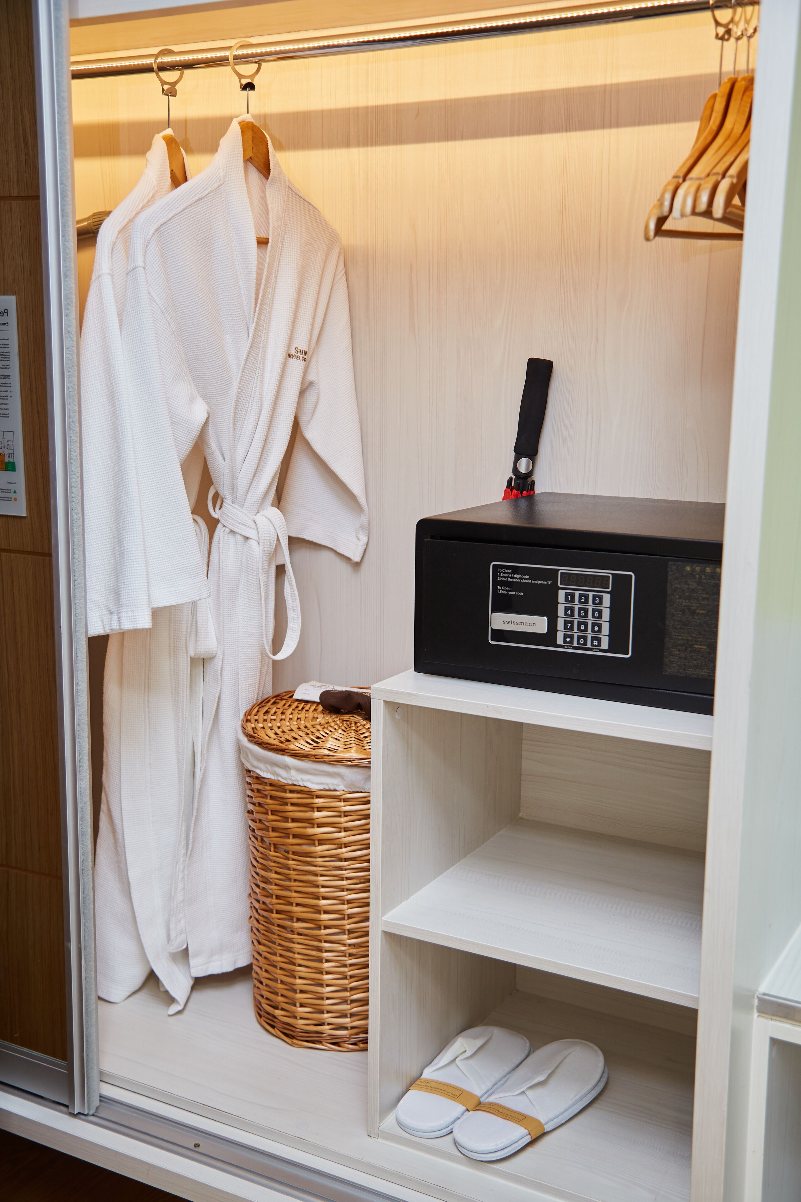 Una camera d'albergo con accappatoio, ciabatte, radio e un cesto.