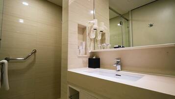 Casa de banho com lavatório, espelho, porta-toalhas e secador de cabelo.