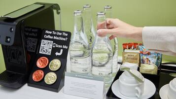 A coffee machine, three glass bottles, a QR code, and a sign with instructions.