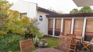 Une terrasse dotée de meubles en bois et de plantes en pot.