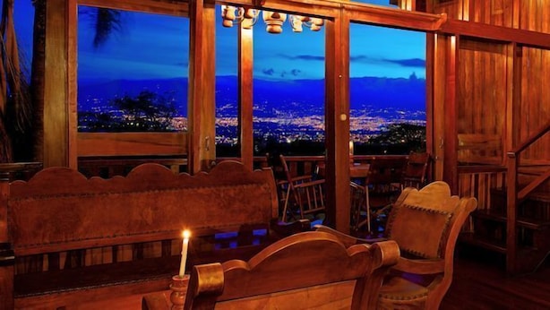 A wooden interior with a view of a cityscape at night. - Escazu Vacation  Rentals, Studio Apartments and standard rooms (San Jose)