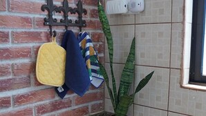 A kitchen with a granite countertop, a stove, a potted plant, and hanging kitchen towels. - Oasis in Downtown next to Simon Bolivar Park with private balcony (San José)