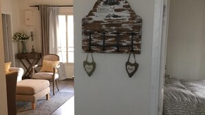 Une pièce comprenant un lit, une chaise, une petite table et un élément décoratif fixé au mur.